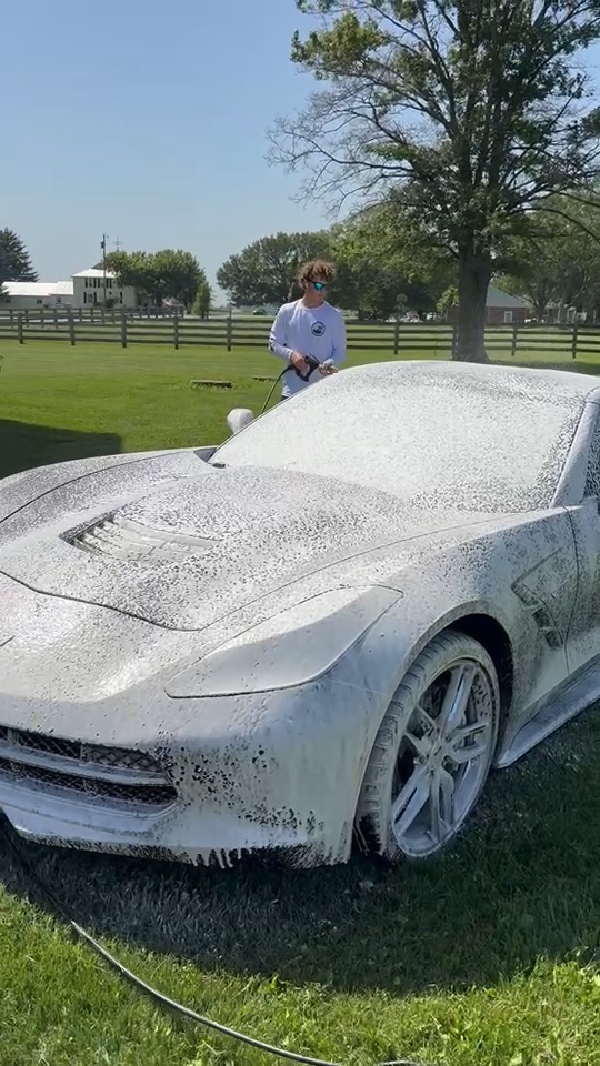 Black Corvette covered in snow foam during an exterior wash